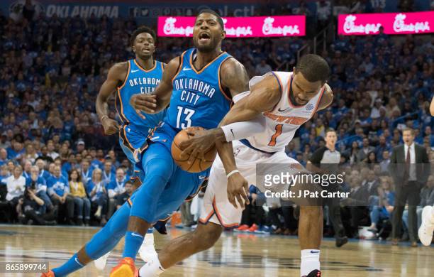 Ramon Sessions of the New York Knicks tries to strip the ball away from Paul George of the Oklahoma City Thunder during the first half of a NBA game...