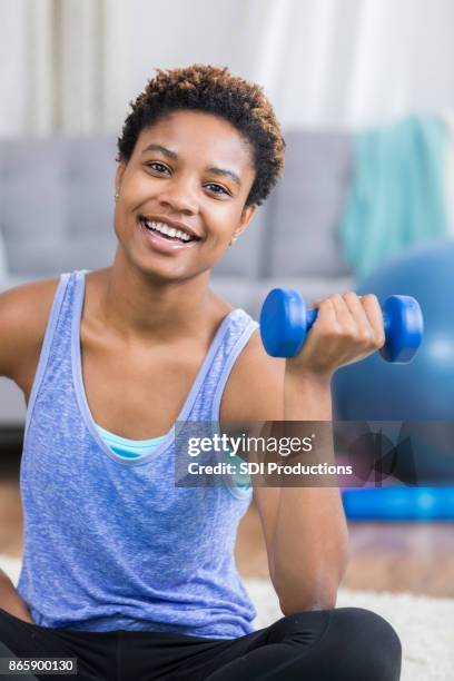 closeup of young woman exercising with hand weight at home - hand weight stock pictures, royalty-free photos & images