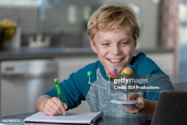 cheerful middle school boy works on science homework - 1 earth productions stock pictures, royalty-free photos & images