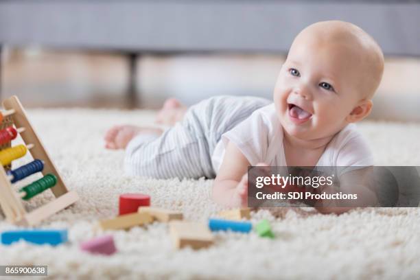 söt baby sjunger med öppen mun när du spelar med träklossar - krypa bildbanksfoton och bilder