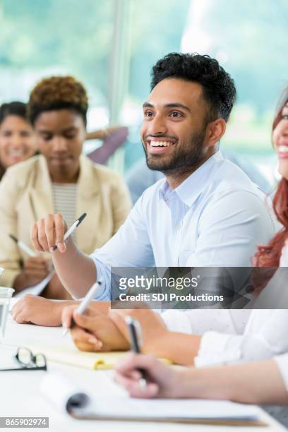 smiling business professional attends finance conference - interested listener stock pictures, royalty-free photos & images