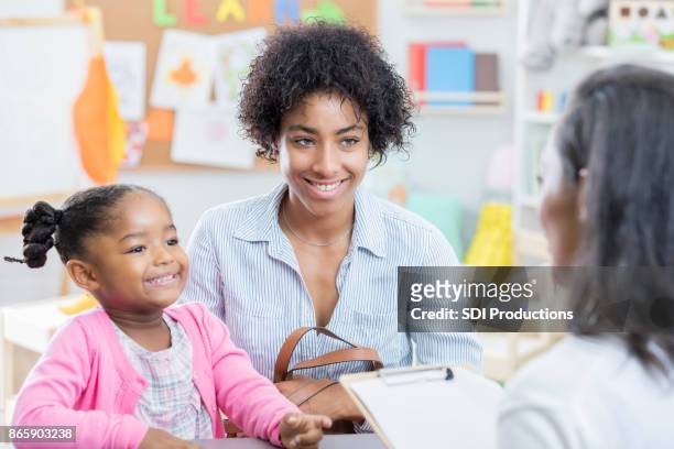 african american mom talks with teacher during conference - parent stock pictures, royalty-free photos & images