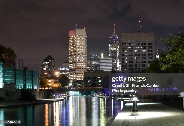 indianapolis skyline illuminated at night and reflected on white river canal in indiana, usa - indianapolis canal stock pictures, royalty-free photos & images