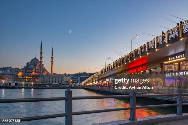 dining on galata bridge at night with new mosque in the background,eminonu,istanbul,turkey - plaza eminonu fotografías e imágenes de stock