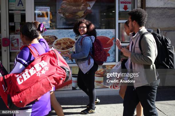 Girl gestures as she walks in Harlem neighborhood of New York City, United States on October 20, 2017. 116th street is long known for it's jazz...