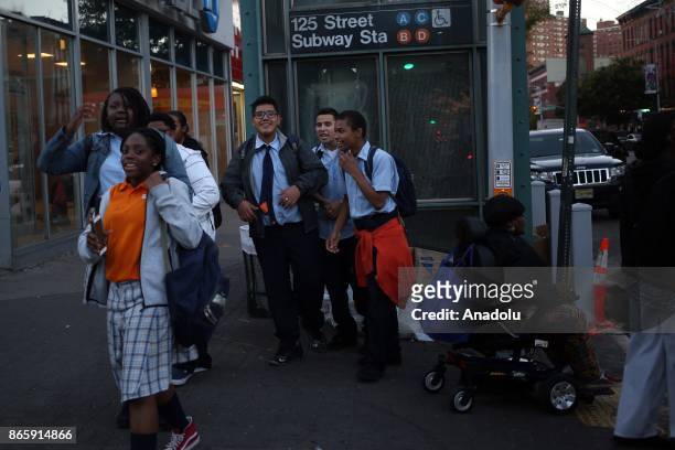 People walk on the 125th street of Harlem neighborhood of New York City, United States on October 20, 2017. 116th street is long known for it's jazz...