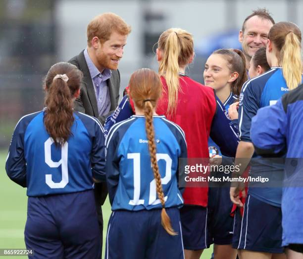 Prince Harry meets young women taking part in a football training session during a visit to the Sir Tom Finney Soccer Development Centre at the UCLan...