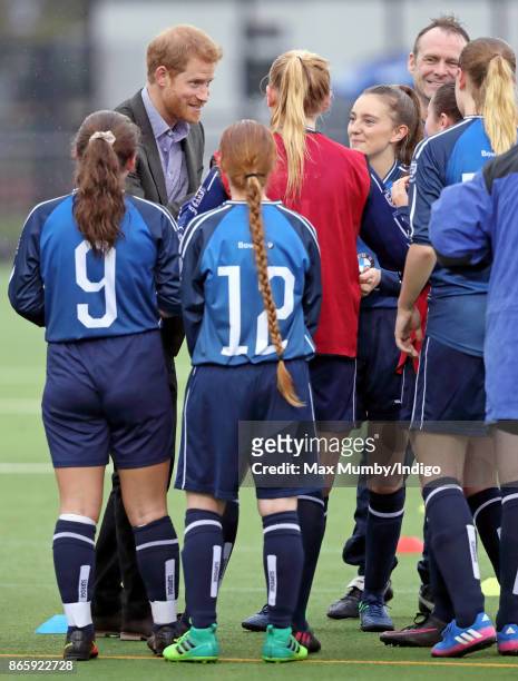 Prince Harry meets young women taking part in a football training session during a visit to the Sir Tom Finney Soccer Development Centre at the UCLan...