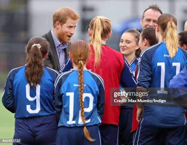 Prince Harry meets young women taking part in a football training session during a visit to the Sir Tom Finney Soccer Development Centre at the UCLan...