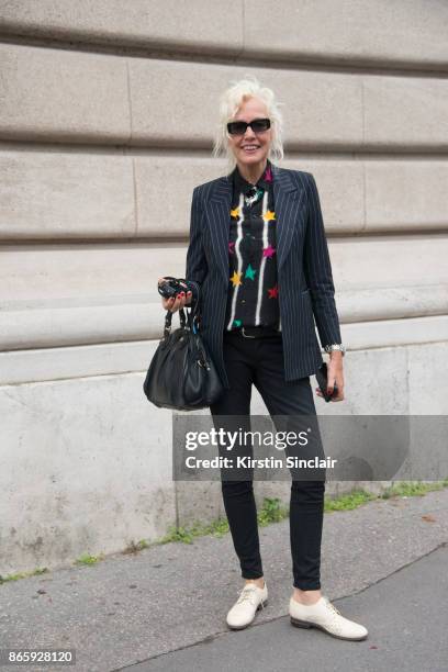 Photographer Ellen Von Unwerth wears a Saint Laurent jacket and shirt, Hedi Slimane pants and Marc Jacobs bag day 2 of Paris Womens Fashion Week...