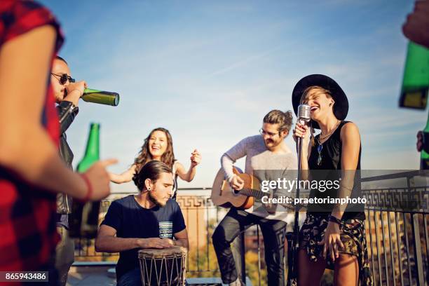 grupo de amigos celebran con un concierto en la azotea - banda fotografías e imágenes de stock