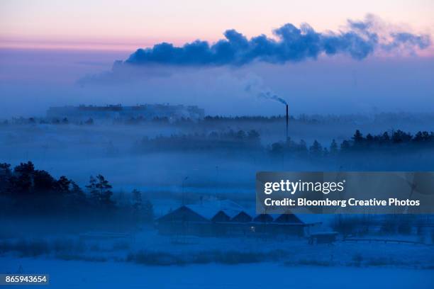 an industrial chimney emits vapor into the sky at night in yakutsk - republik sacha stock-fotos und bilder