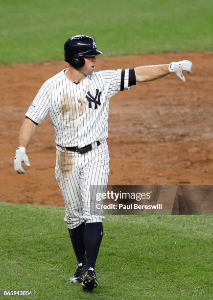 Brett Gardner of the New York Yankees looks back to teammate Aaron Judge at second base and signals a thumbs down after Judge hit an rbi double that...