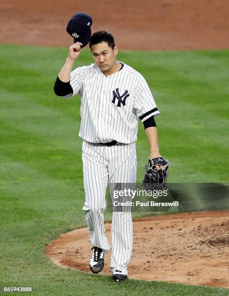 Pitcher Masahiro Tanaka of the New York Yankees tips his cap to the crowd as he leaves the field after pitching in the third inning of game 5 of the...