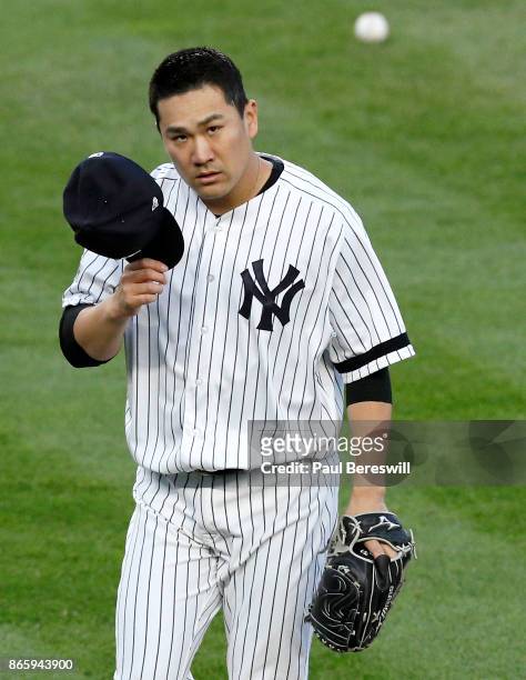 Pitcher Masahiro Tanaka of the New York Yankees tips his cap to the crowd as he leaves the field after pitching in the second inning of game 5 of the...