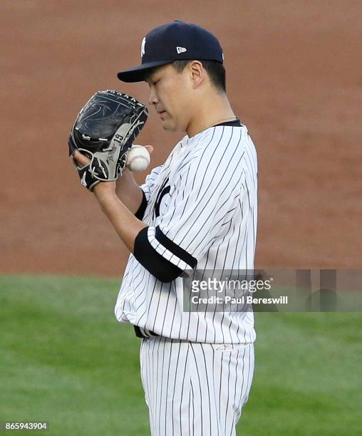 Pitcher Masahiro Tanaka of the New York Yankees stares into his glove in game 5 of the American League Championship Series against the Houston Astros...