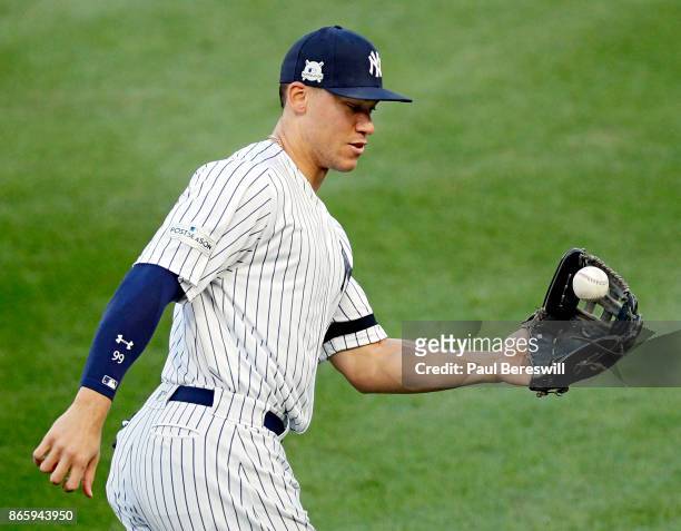 Aaron Judge of the New York Yankees catches the ball as he runs out to the outfield at the start of game 5 of the American League Championship Series...