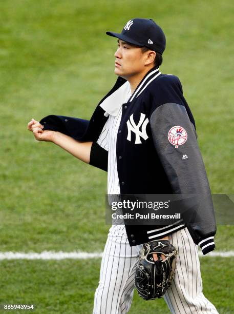 Pitcher Masahiro Tanaka of the New York Yankees walks in from the bullpen to start game 5 of the American League Championship Series against the...
