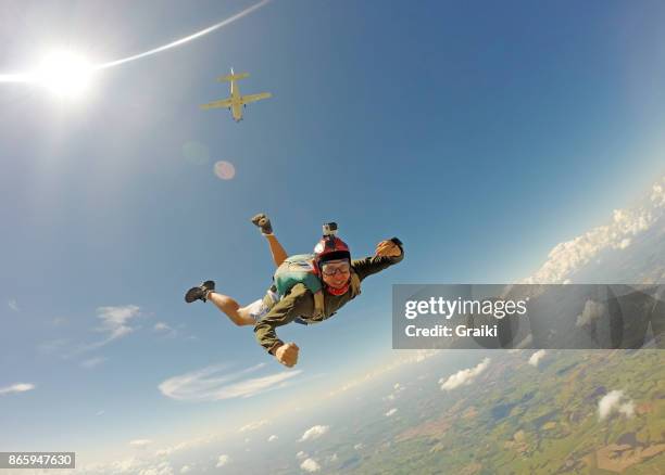 young man in casual clothes jumping from parachute. - skydiving stock pictures, royalty-free photos & images