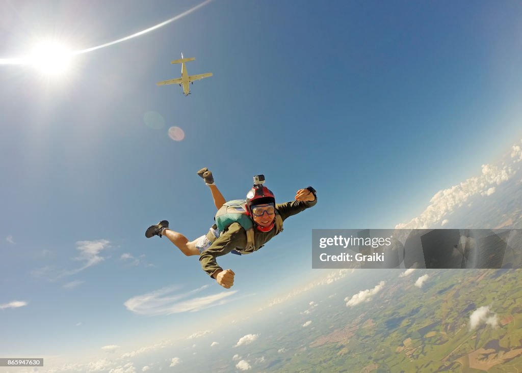Young man in casual clothes jumping from parachute.