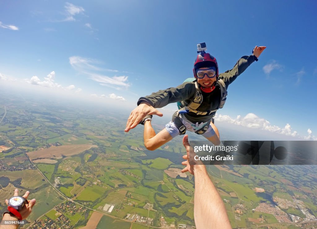 Young man in casual clothes jumping from parachute.