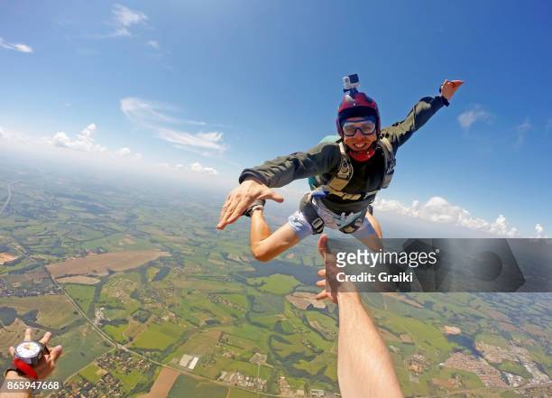 young man in casual clothes jumping from parachute. - fallschirmsprung stock-fotos und bilder