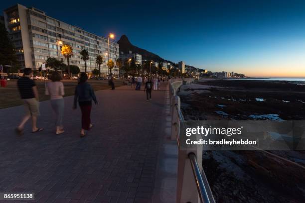 people walking along sea point promenande at sunset - sea point cape town stock pictures, royalty-free photos & images