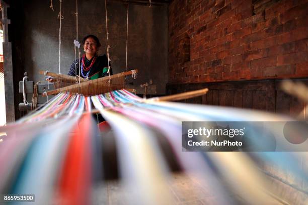 Woman in a traditional attire weaving traditional fabrics during inauguration ceremony of Jyapu Museum on the occasion of 72nd United Nations Day in...