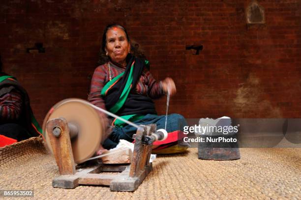 Woman in a traditional attire rolls wool during inauguration ceremony of Jyapu Museum on the occasion of 72nd United Nations Day in Chyasal,...