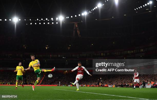 Arsenal's French striker Olivier Giroud crosses the ball past Norwich City's Portuguese defender Ivo Pinto during the English League Cup fourth round...