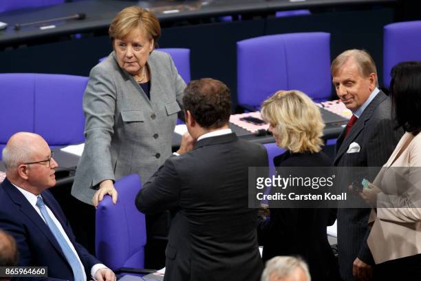 German Chancellor Angela Merkel discusses with Volker Kauder , leader of the CDU/CSU Bundestag faction and other parliamentarians during the opening...