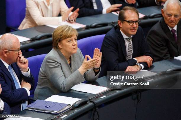 German Chancellor Angela Merkel applauds flanked by Volker Kauder , leader of the CDU/CSU Bundestag faction, German Transport Minister Alexander...