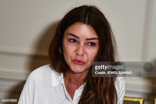 Mimi Haleyi, a former production assistant, wipes tears during a press conference in New York on October 24, 2017 as she alleges to have been...