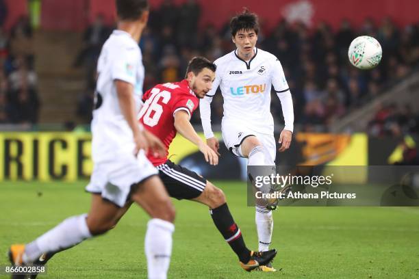 Ki Sung-yueng of Swansea City is marked by Matteo Darmian of Manchester United during the Carabao Cup Fourth Round match between Swansea City and...