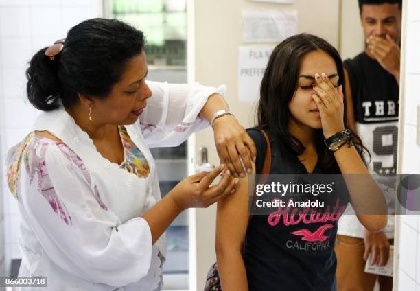 Health agent vaccinates people during a campaign of vaccination against yellow fever in Sao Paulo, Brazil October 24, 2017. Brazil is undergoing its...