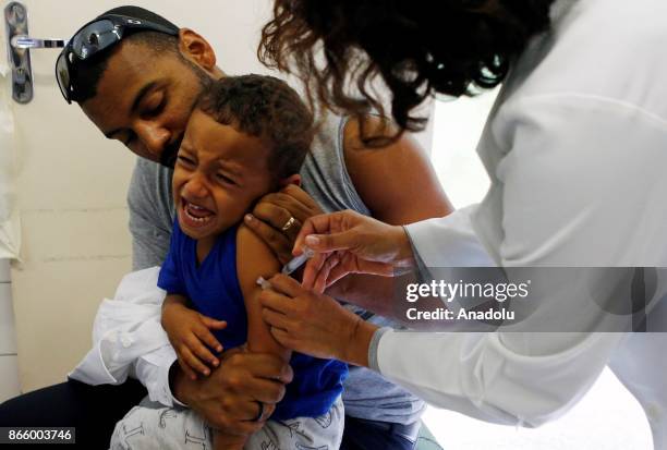 Health agent vaccinates a child during a campaign of vaccination against yellow fever in Sao Paulo, Brazil October 24, 2017. Brazil is undergoing its...
