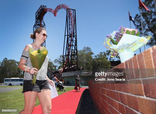 Gold Coast local Amanda Bonney places flowers at the entrance to Dreamworld on October 25, 2017 in Gold Coast, Australia. Four people were killed...