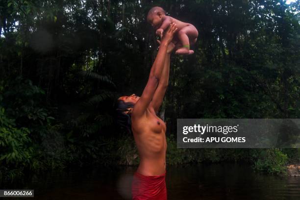 Meri Waiapi bathes with her cousin at the Feliz river in the Waiapi indigenous reserve in Amapa state in Brazil on October 14, 2017. Tribal chieftain...