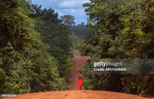 Waiapi man walks on the road in the Waiapi indigenous reserve in Amapa state in Brazil on October 15, 2017. Tribal chieftain Tzako Waiapi perfectly...