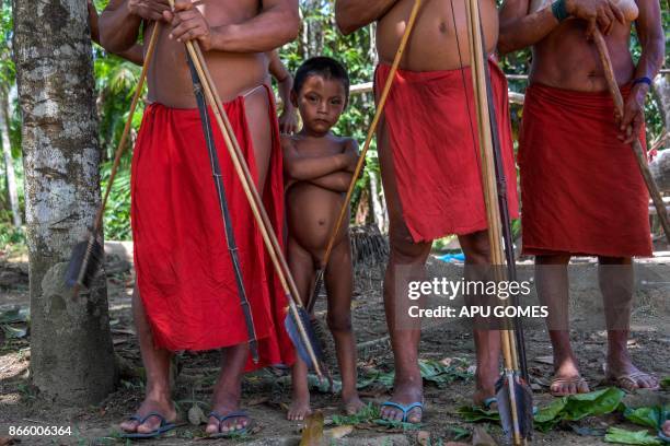 Waiapi boy stands behind adults at the Pinoty village in Waiapi indigenous reserve in Amapa state in Brazil on October 12, 2017. Tribal chieftain...