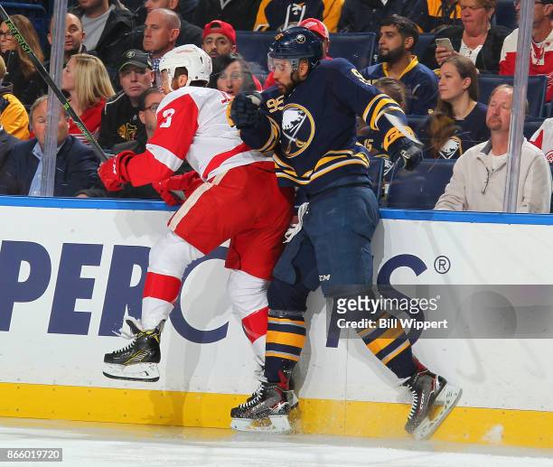 Justin Bailey of the Buffalo Sabres checks Nick Jensen of the Detroit Red Wings during an NHL game on October 24, 2017 at KeyBank Center in Buffalo,...