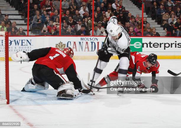 Kurtis MacDermid of the Los Angeles Kings dekes with the puck on a breakaway as Mike Condon and Chris Wideman of the Ottawa Senators defend against...