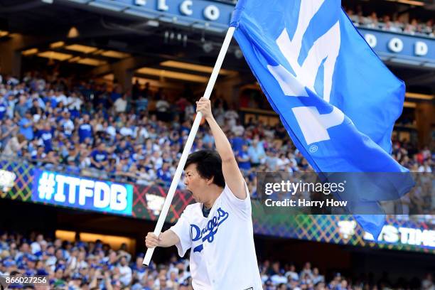Actor and comedian Ken Jeong waves a Los Angeles Dodgers flag before game one of the 2017 World Series between the Houston Astros and the Los Angeles...