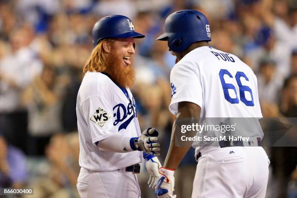 Justin Turner of the Los Angeles Dodgers celebrates with Yasiel Puig after hitting a two-run home run during the sixth inning against the Houston...