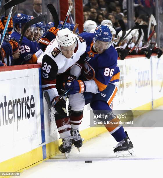 Christian Fischer of the Arizona Coyotes is hit into the boards by Nikolay Kulemin of the New York Islanders at the Barclays Center on October 24,...