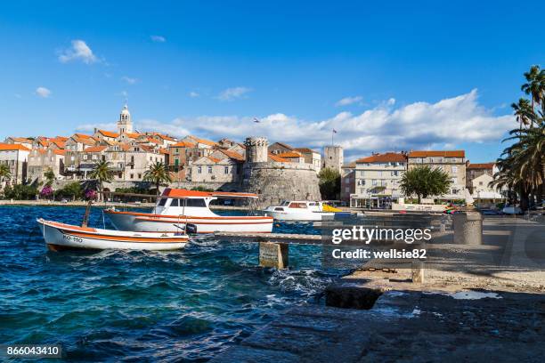 boats bob on the choppy waters by korcula old town - korcula island stock pictures, royalty-free photos & images