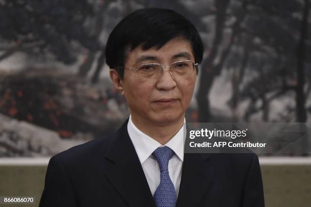 Wang Huning, a member of the Political Bureau Central Committee, stands as he is introduced as a new member of the Communist Party of China's...