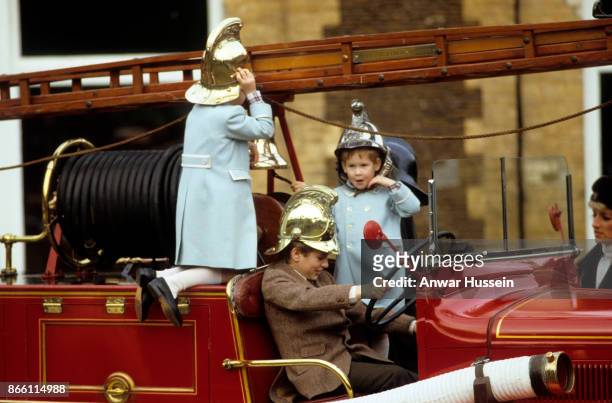 Prince William,Prince Harry and Peter Phillips play on a fire engine on January 03, 1988 in Sandringham, England.