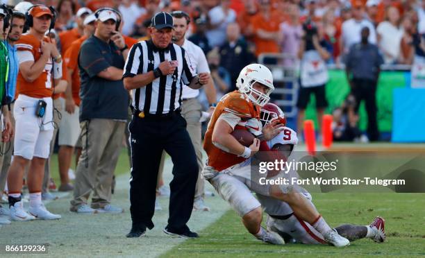 Texas quarterback Sam Ehlinger is hit at the sidelines by Oklahoma linebacker Kenneth Murray in the fourth quarter of the Red River Showdown at the...