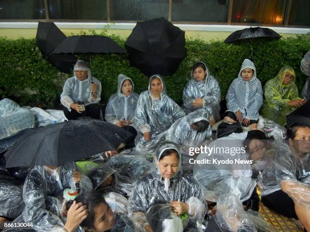 Huge crowds of mourners camp out in the pouring rain along the royal funeral route in the Rattanakosin areas in Bangkok on Oct. 24 ahead of the royal...